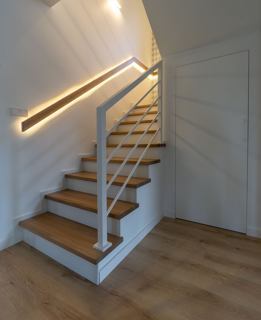 Obłożenie schodów na beton z efektownym podświetleniem LED zamontowanym za pochwytem.